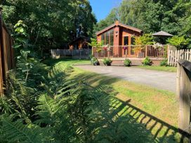 A cabin with a deck and surrounding greenery at Tiggywinkle Beck - White Cross Bay Windermere