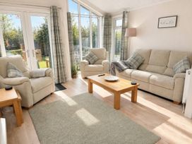 A living room with a sofa and armchairs at Tiggywinkle Beck - White Cross Bay in Windermere