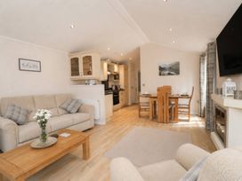 A living room with a sofa and dining area at Tiggywinkle Beck - White Cross Bay Windermere