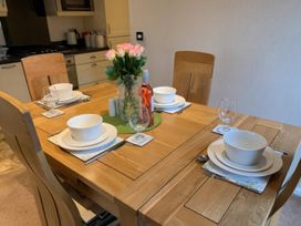 A dining table set with plates and glasses at Tiggywinkle Beck - White Cross Bay, Windermere