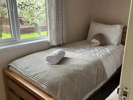 A single bed with a pillow and towel in a bedroom at Tiggywinkle Beck - White Cross Bay Windermere