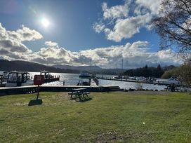 A view of boats at a pier with a picnic table and water at Tiggywinkle Beck - White Cross Bay Windermere