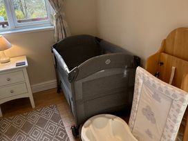 A nursery with a crib and changing station at Owls House - White Cross Bay in Windermere