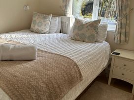 A bedroom with a bed and bedside table at Owls House - White Cross Bay in Windermere
