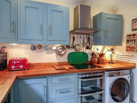 A kitchen with cabinets, a toaster, and a washing machine at 17 Demesne Gardens, Ipswich