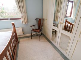 A bedroom with a bed, chair, and wardrobe at 17 Demesne Gardens, Ipswich