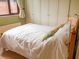 A bedroom with a bed and wardrobe at 17 Demesne Gardens in Ipswich