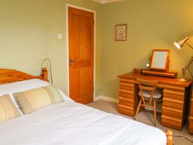 A bedroom with a bed and a desk at 17 Demesne Gardens in Ipswich