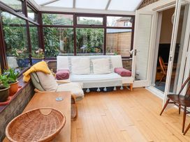 A conservatory with a sofa, table, and plants at 17 Demesne Gardens, Ipswich