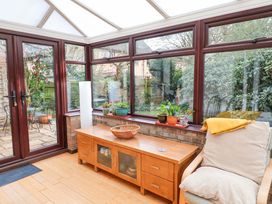 A conservatory with a table and plants at 17 Demesne Gardens in Ipswich