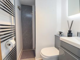 A bathroom with a toilet, sink, and shower at Caban Tan Y Dderwen in Chwilog