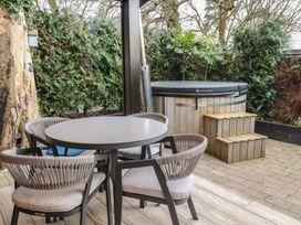 A garden with a hot tub and seating area at Caban Tan Y Dderwen in Chwilog