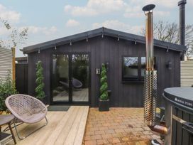 An outdoor area with a hot tub and seating at Caban Tan Y Ffawydd in Chwilog near Y Ffor