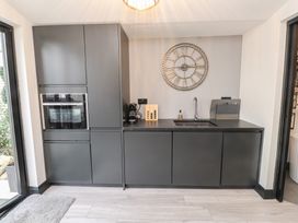 A kitchen with cabinets, an oven and a sink at Caban Tan Y Ffawydd Chwilog near Y Ffor