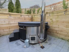 A hot tub on a patio in an outdoor area at Riverside Lodge Afonwen