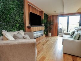 A living room with sofas and a television at Riverside Lodge in Afonwen