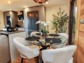 A dining room with a glass table and chairs at Riverside Lodge in Afonwen