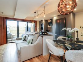 A kitchen with a sofa and dining table at Riverside Lodge Afonwen