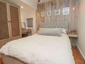 A bedroom with a bed and wardrobe at Riverside Lodge Afonwen