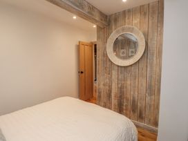 A bedroom with a bed and a mirror at Riverside Lodge Afonwen