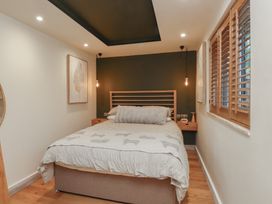 A bedroom with a bed and bedside table at Riverside Lodge Afonwen