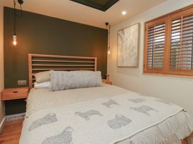 A bedroom with a bed and wall art at Riverside Lodge Afonwen