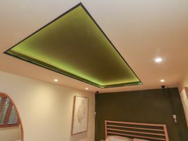 A bedroom with a green ceiling and light fixture at Riverside Lodge Afonwen