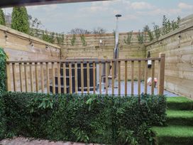 A garden with decking and seating area at Riverside Lodge Afonwen