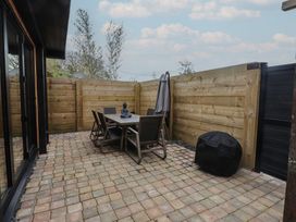 An outdoor patio with a table and chairs at Riverside Lodge Afonwen