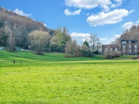 A grassy area with trees and a building at 40 Raleigh Court in Sherborne