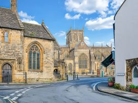 A church with a clock tower and stone buildings at 40 Raleigh Court in Sherborne