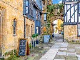 A street with stone buildings and signs at Old Yarn Mills in Sherborne