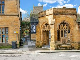 A stone building with an archway and garbage can at 40 Raleigh Court in Sherborne