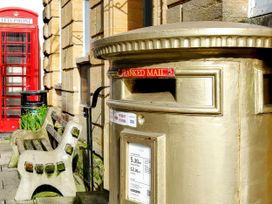 A postbox and telephone booth near a bench at 40 Raleigh Court in Sherborne