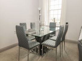 A dining room with a glass table and chairs at The Sea Chest in Alnmouth