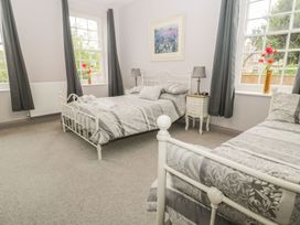 A bedroom with two beds and a bedside table at The Sea Chest in Alnmouth