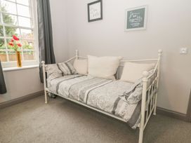 A bedroom with a sofa bed and decorative frames at The Sea Chest in Alnmouth