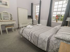 A bedroom with a bed and wardrobe at The Sea Chest in Alnmouth