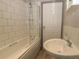 A bathroom with a bath tub, shower, and sink at The Sea Chest in Alnmouth