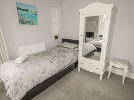 A bedroom with a bed and a mirror at The Sea Chest in Alnmouth