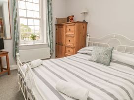 A bedroom with a bed and wardrobe at The Sea Chest in Alnmouth