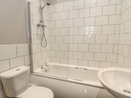 A bathroom with a bathtub, shower, toilet, and sink at The Sea Chest in Alnmouth