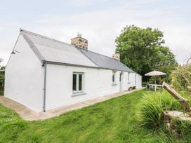 A cottage with a garden and outdoor umbrella at Rhos Y Clegryn in Goodwick