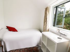 A bedroom with a bed and a window at Rhos Y Clegryn Goodwick