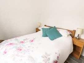 A bedroom with a bed and nightstands at Rhos Y Clegryn in Goodwick