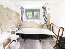 A bathroom with a bathtub and window at Rhos Y Clegryn Goodwick