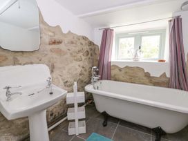 A bathroom with a bathtub, sink, and window at Rhos Y Clegyrn in Goodwick