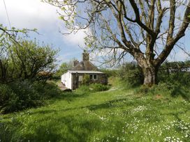 A house surrounded by grass and trees at Rhos Y Clegyrn in Goodwick