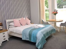 A bedroom with a bed and a table at Apartment 1 in Torquay