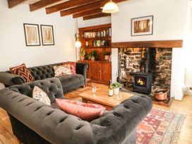 A living room with a sofa, coffee table, and fireplace at Englewood Cottage in Hexham